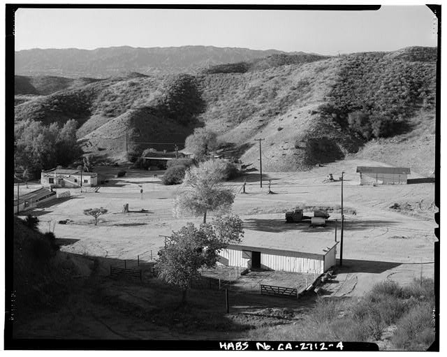 GENERAL VIEW OF WOOD STABLES (FRONT CENTER), WITH POOL CABANA, JOE'S CABIN, BUNKHOUSE, AND ADOBE STABLE TO REAR, LEFT TO RIGHT; CAMERA FACING SOUTH - Harry Carey Ranch, 28515 San Francisquito Canyon Road, Saugus, Los Angeles County, CA